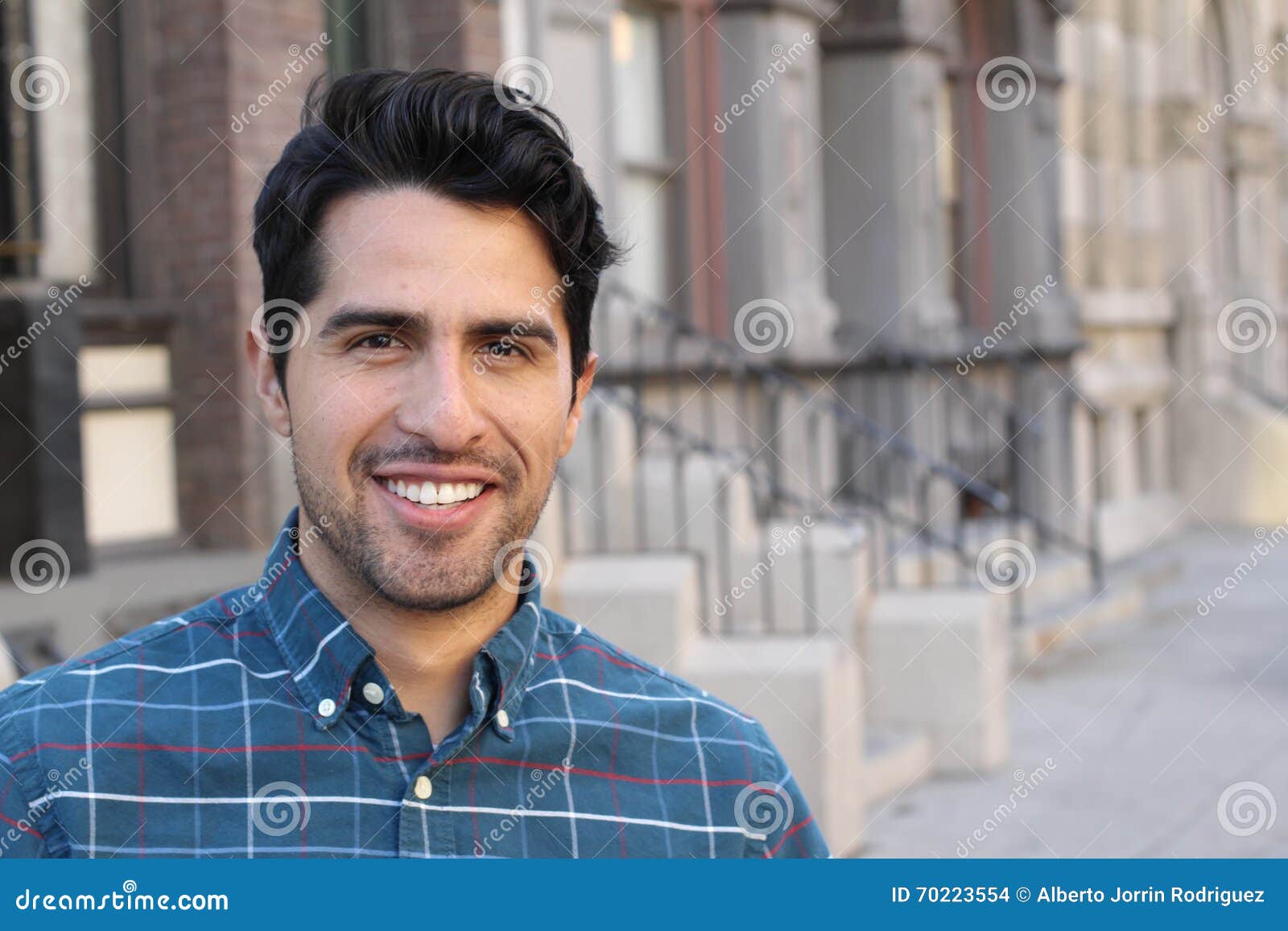 young and attractive latino male smiling in the city