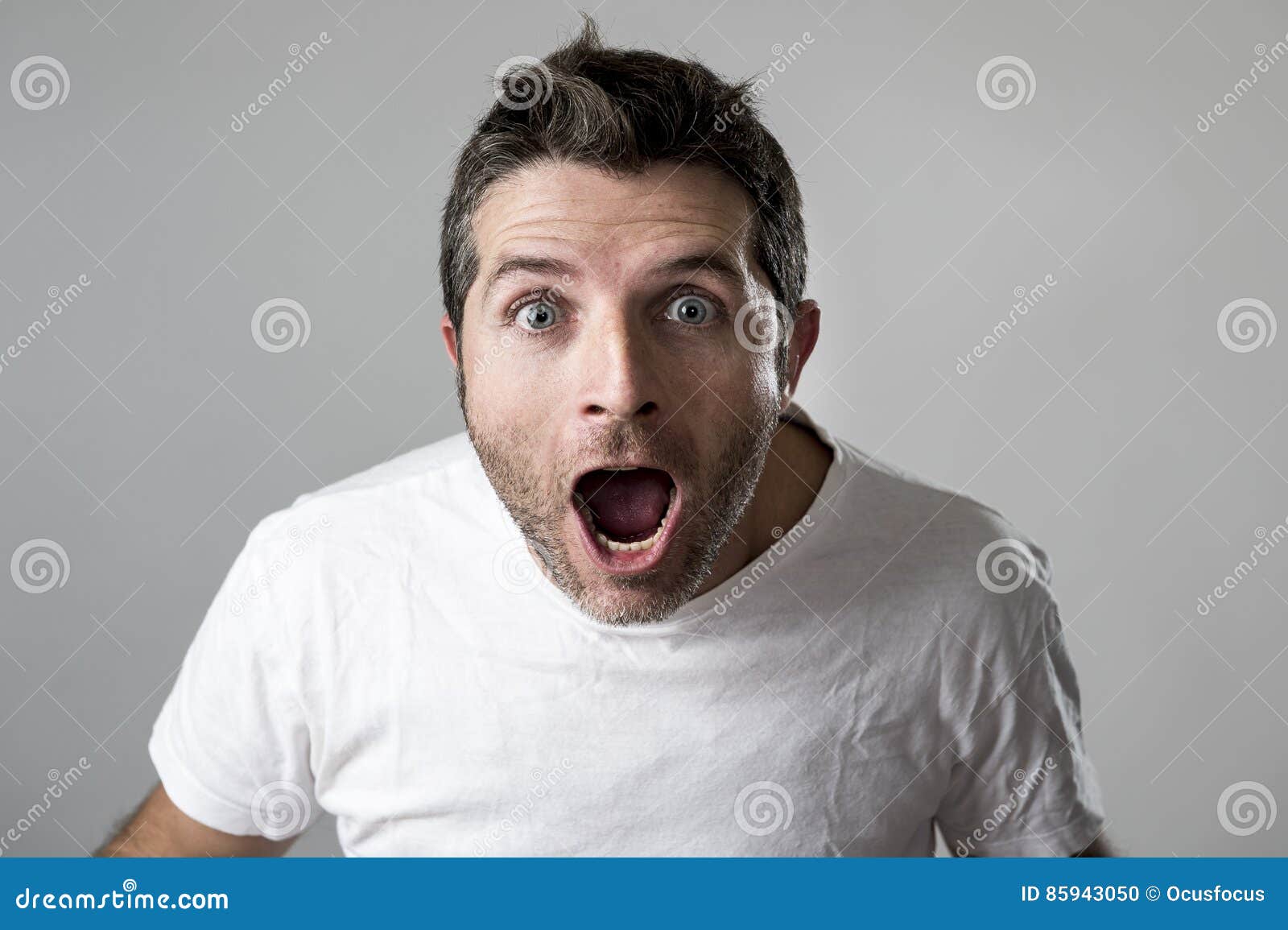 young attractive man astonished amazed in shock surprise face expression and shock emotion