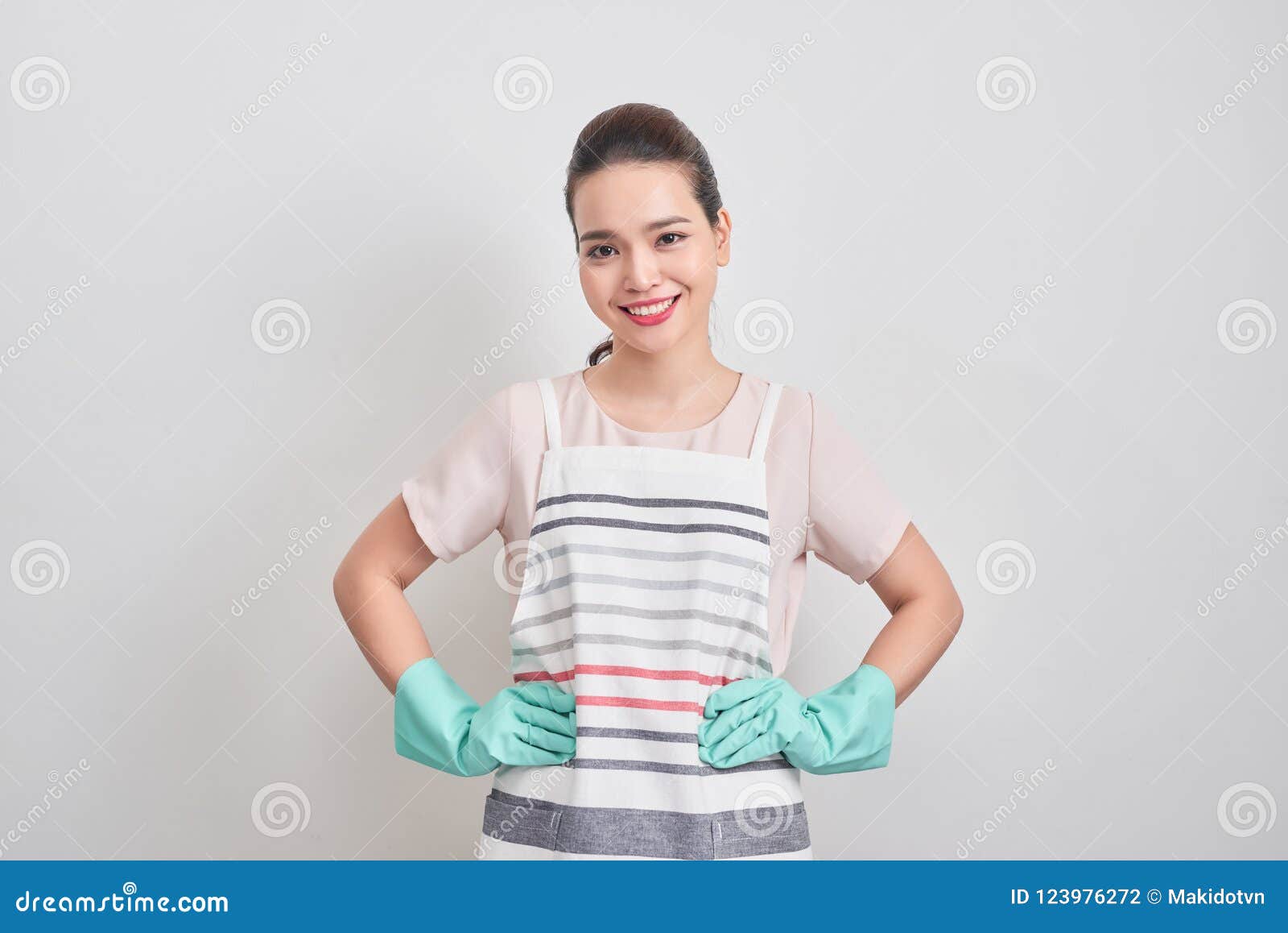 Young Attractive Smiling Housewife In Striped Apron, Blue Glove