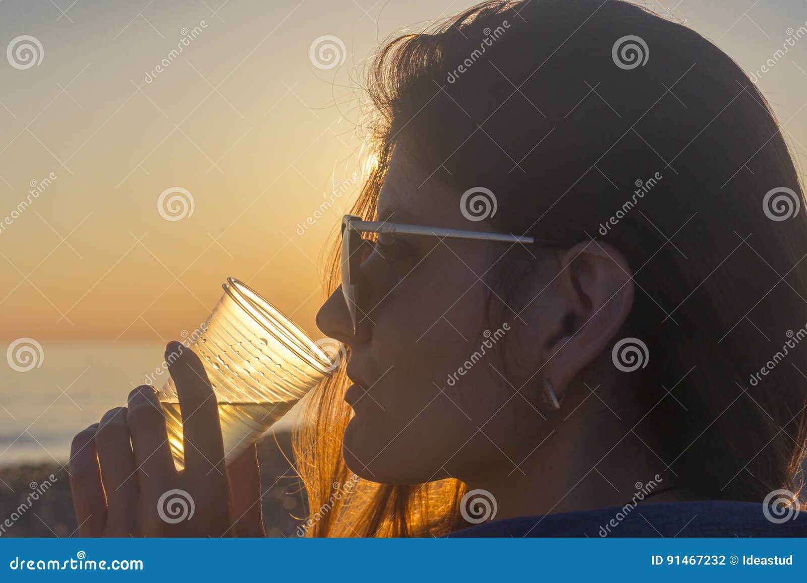 Young Attractive Woman on the Beach at Sunset Drinking from Glass Stock ...