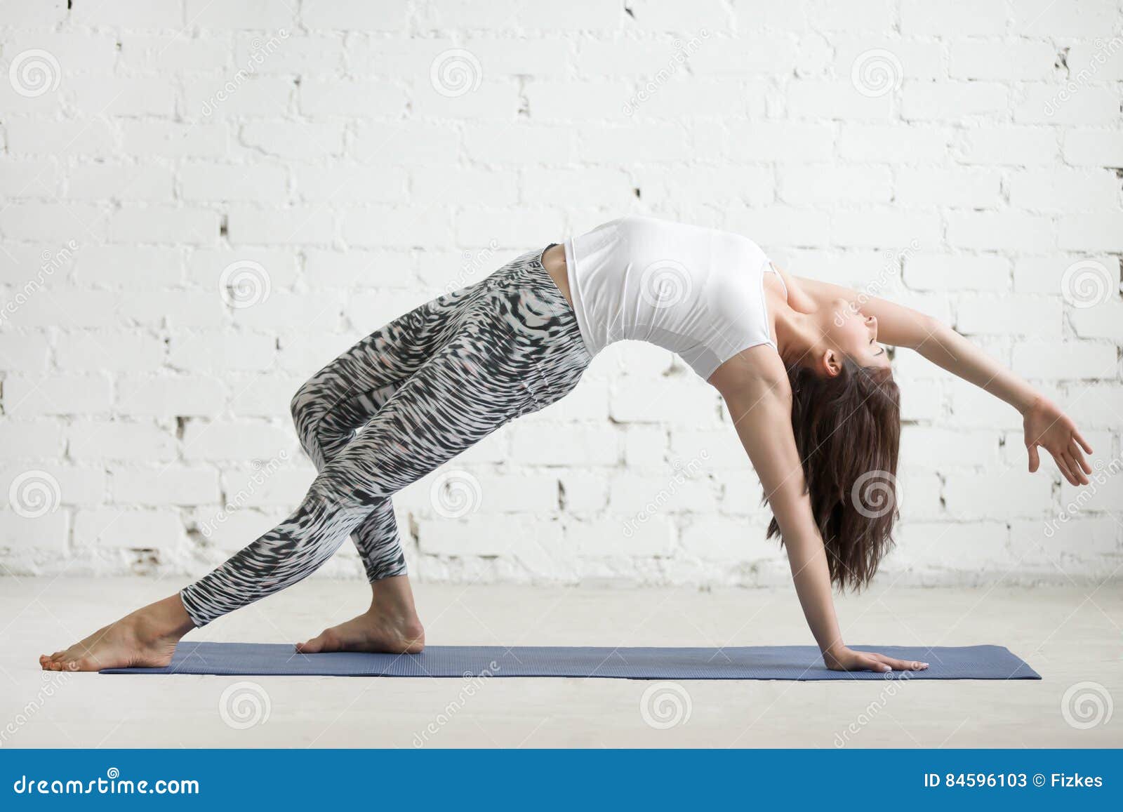 Woman doing Wild Thing yoga pose outdoors. Female practicing