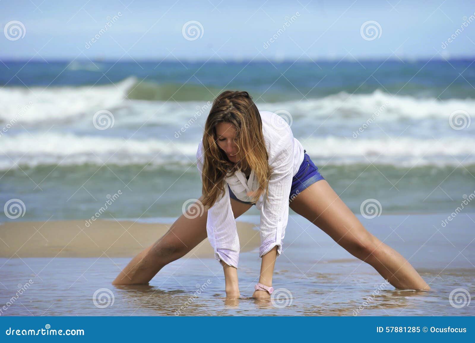 Young Attractive Woman in Shorts and Shirt Playing with Sand on the Beach  with Sea on Her Back Stock Image - Image of female, portrait: 57881285