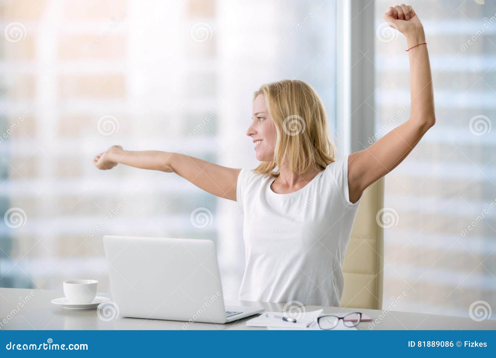 Young Attractive Woman Stretching At Office Desk Stock Photo