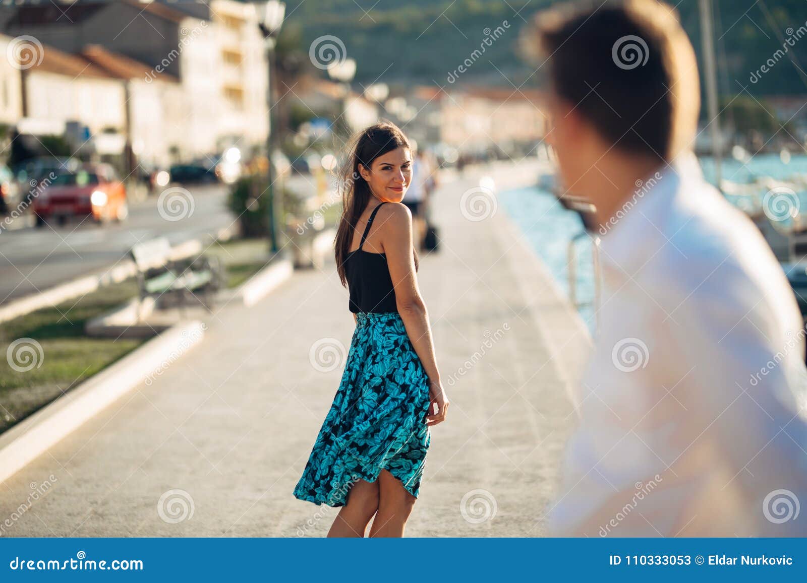 young attractive woman flirting with a man on the street.flirty smiling woman looking back on a handsome man.female attraction