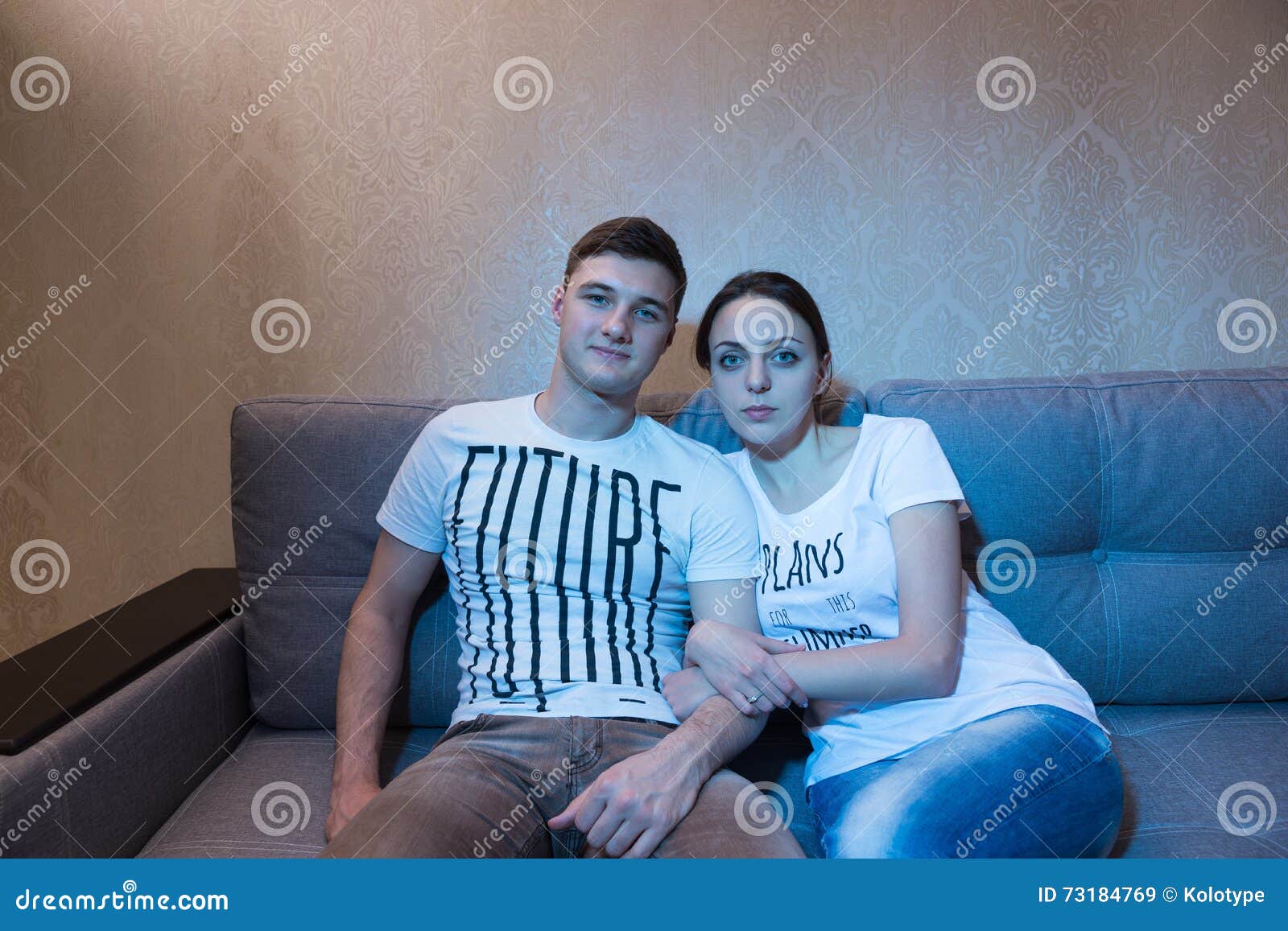 Happy Couple Cuddling And Sitting On The Couch Watching Tv Royalty-Free