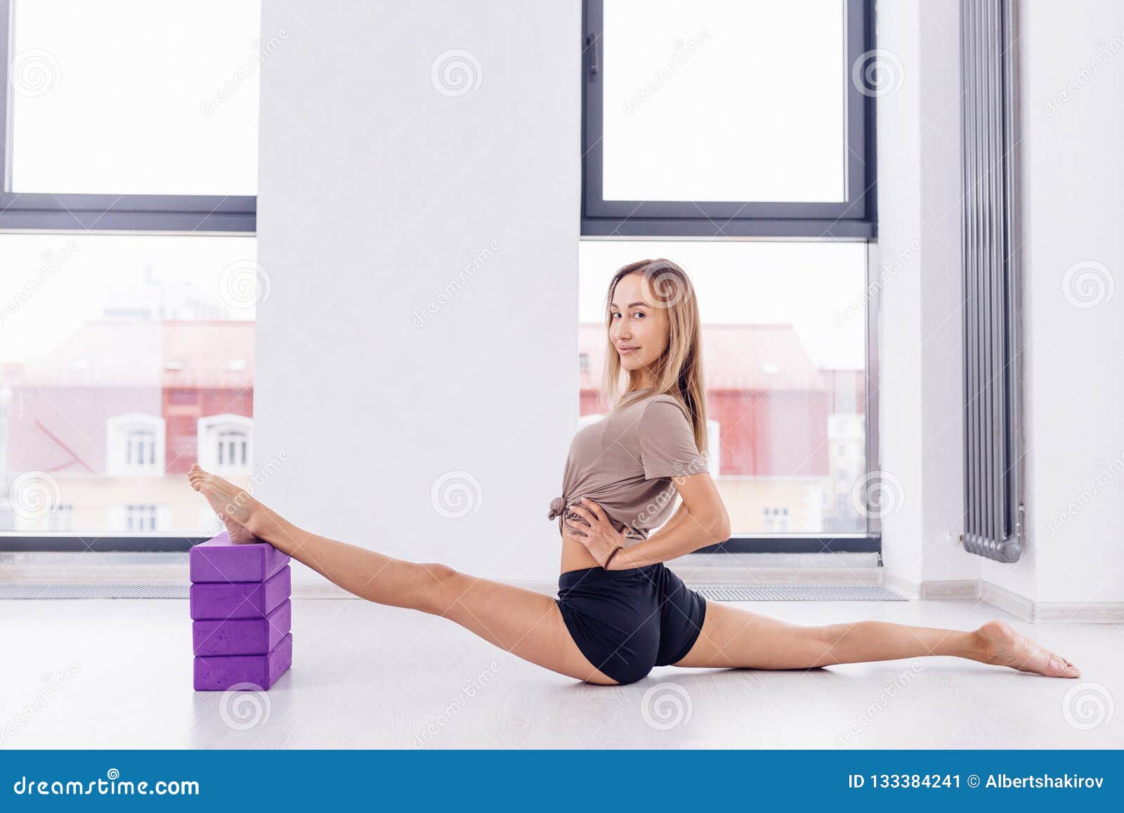 Young Awesome Fit Girl Holding Her Legs On The Pellows And Doing Splits