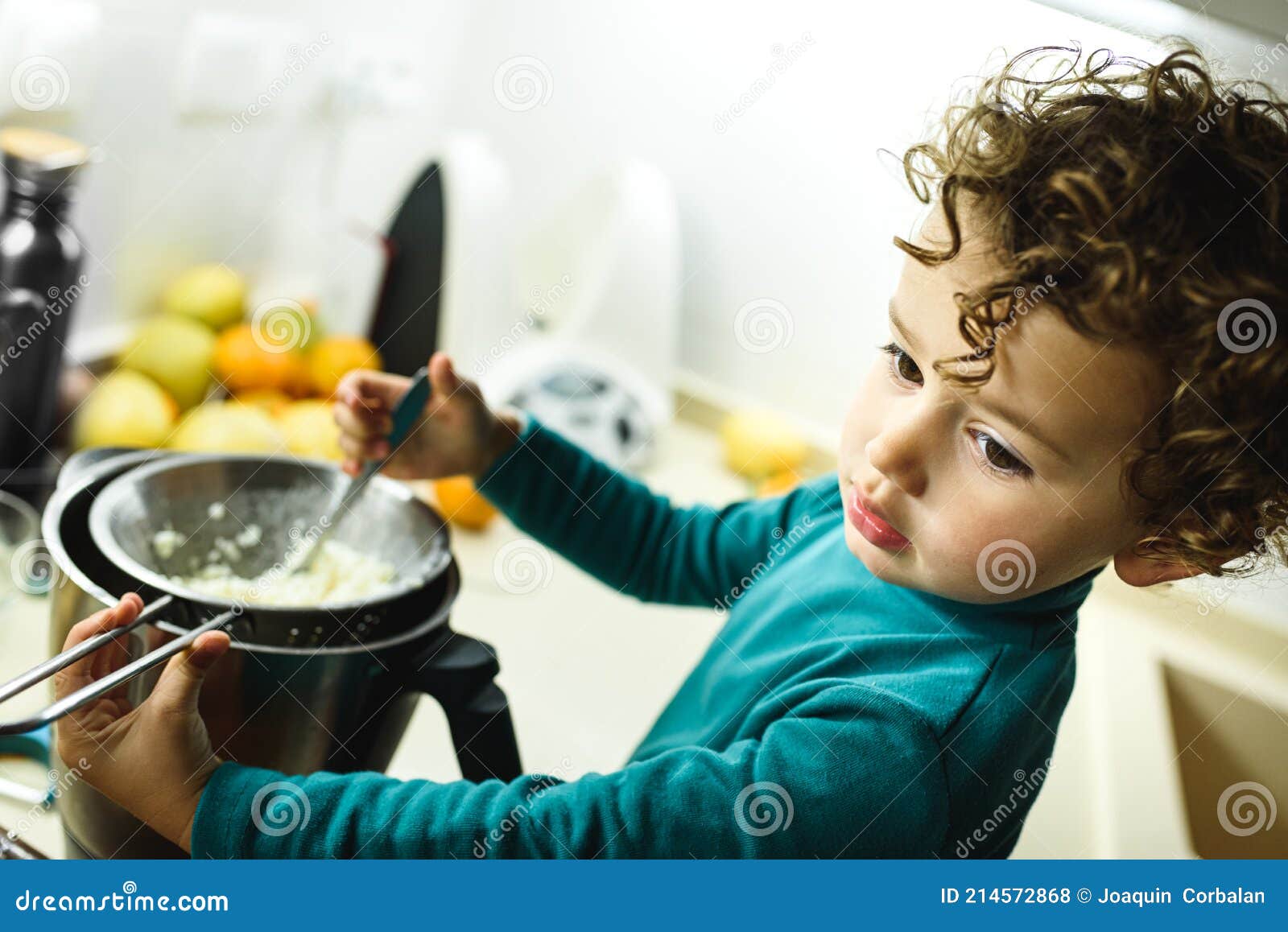 Young Baby Girl Helps Prepare a Cake Using a Food Processor Stock Photo