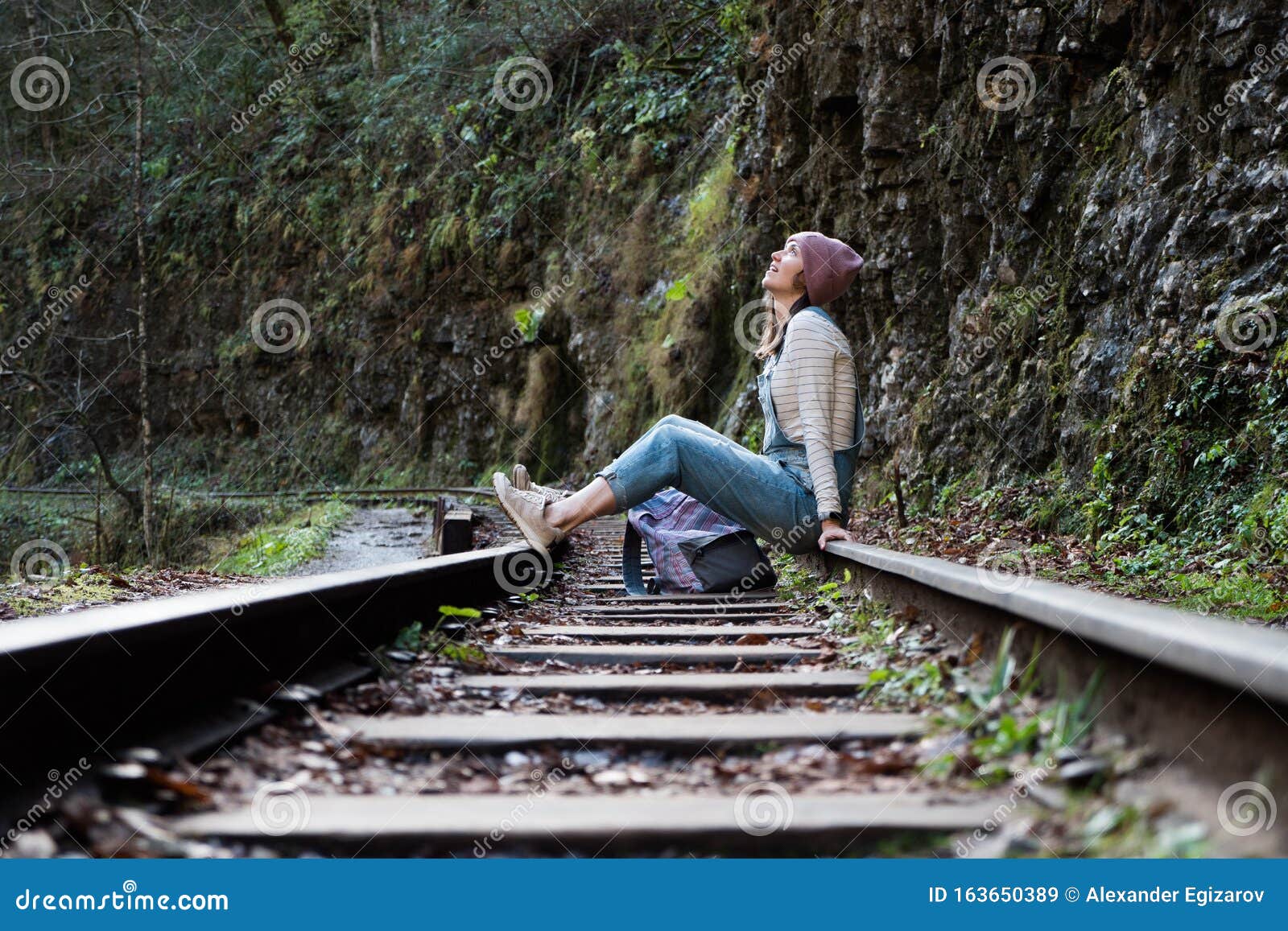 Young Backpacker Woman is Sitting on Train Rail and Resting Alone Stock ...