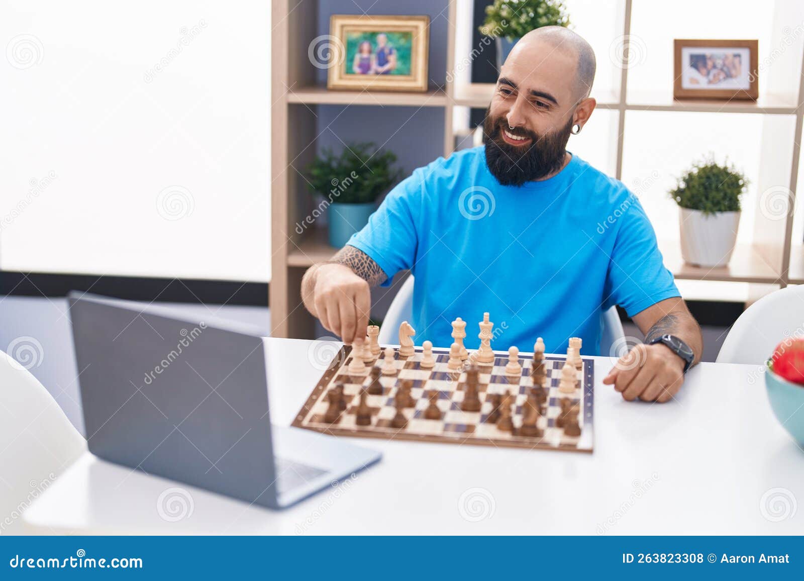 Man playing chess against computer Stock Photo