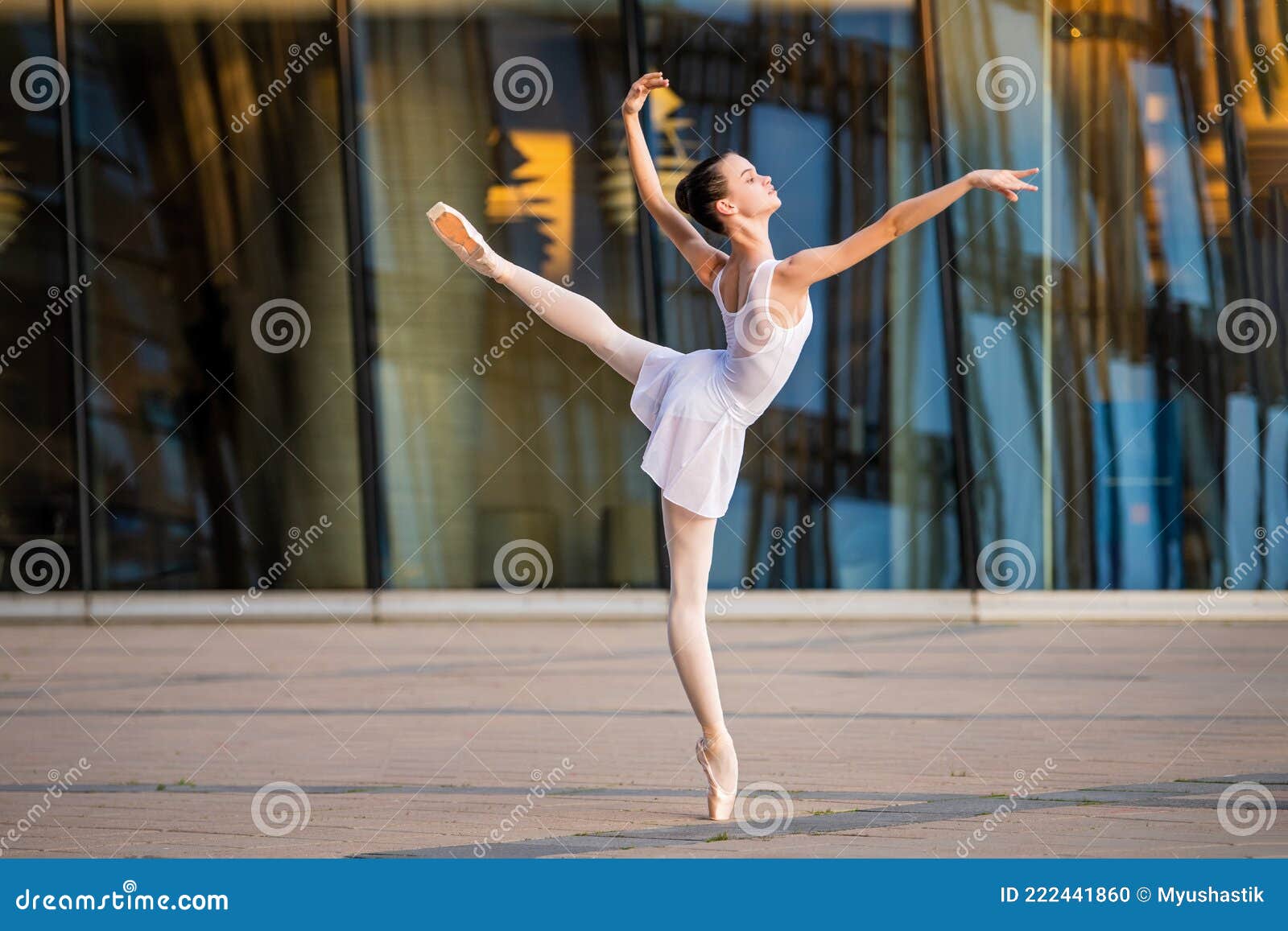 Young Ballerina in a White Leotard Dancing on Pointe Shoes Against the ...