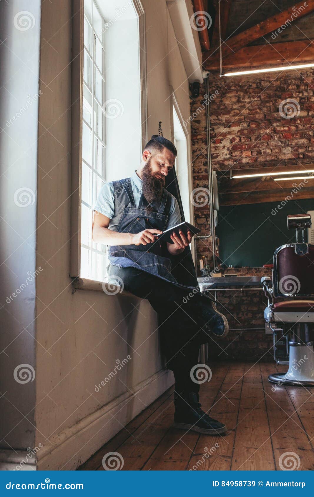 Young Barber at His Barbershop Using Digital Tablet Stock Image - Image ...