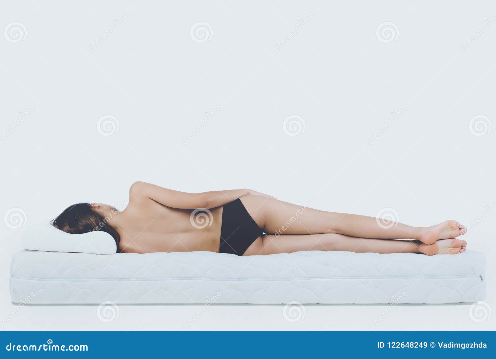 young bare woman lying on orthopedic mattress