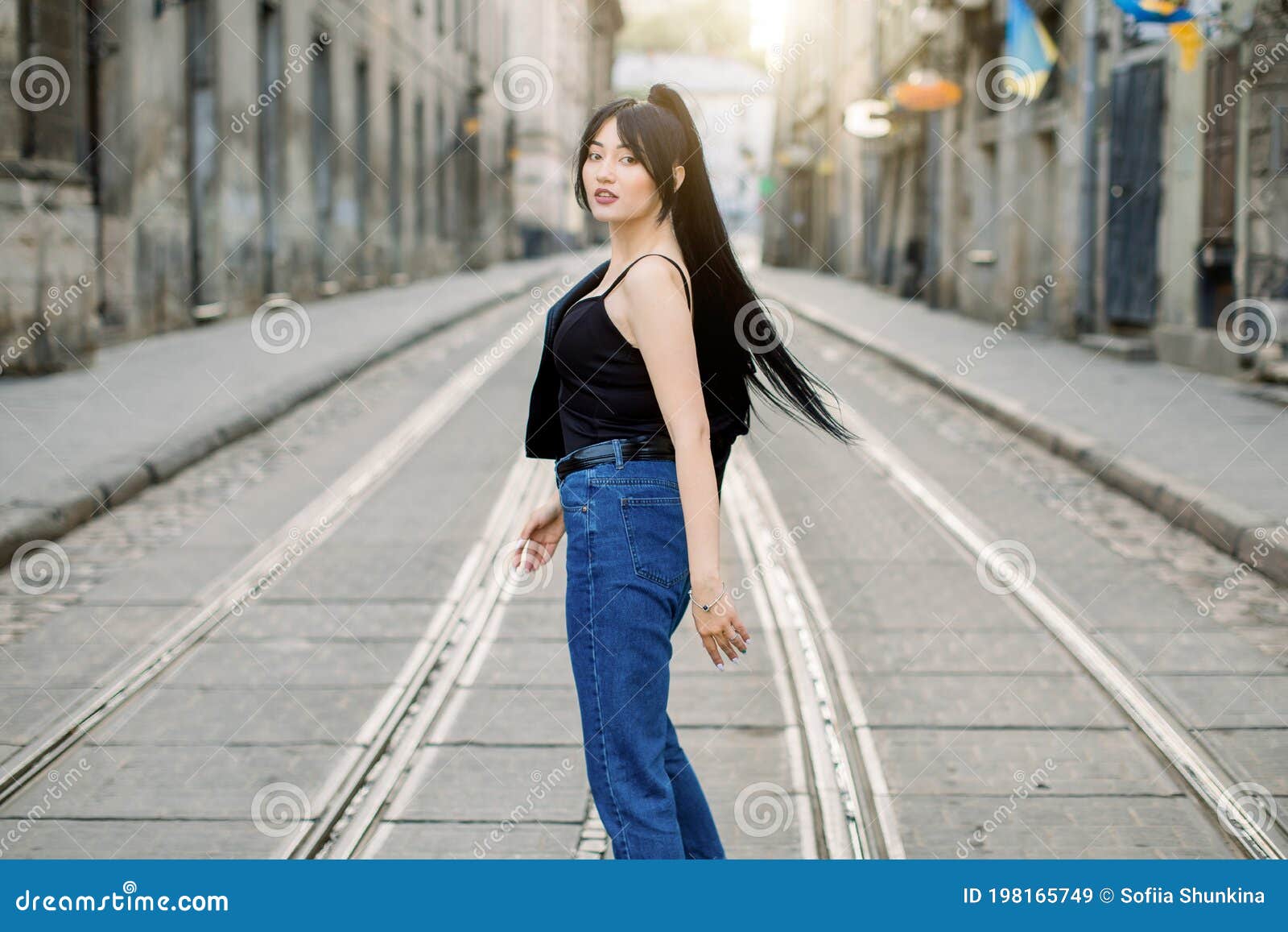 Young Beautiful Asian Girl with Ponytail Black Hair, Wearing Casual Jeans  and Black Top, Turning To Camera and Posing Stock Image - Image of city,  jacket: 198165749