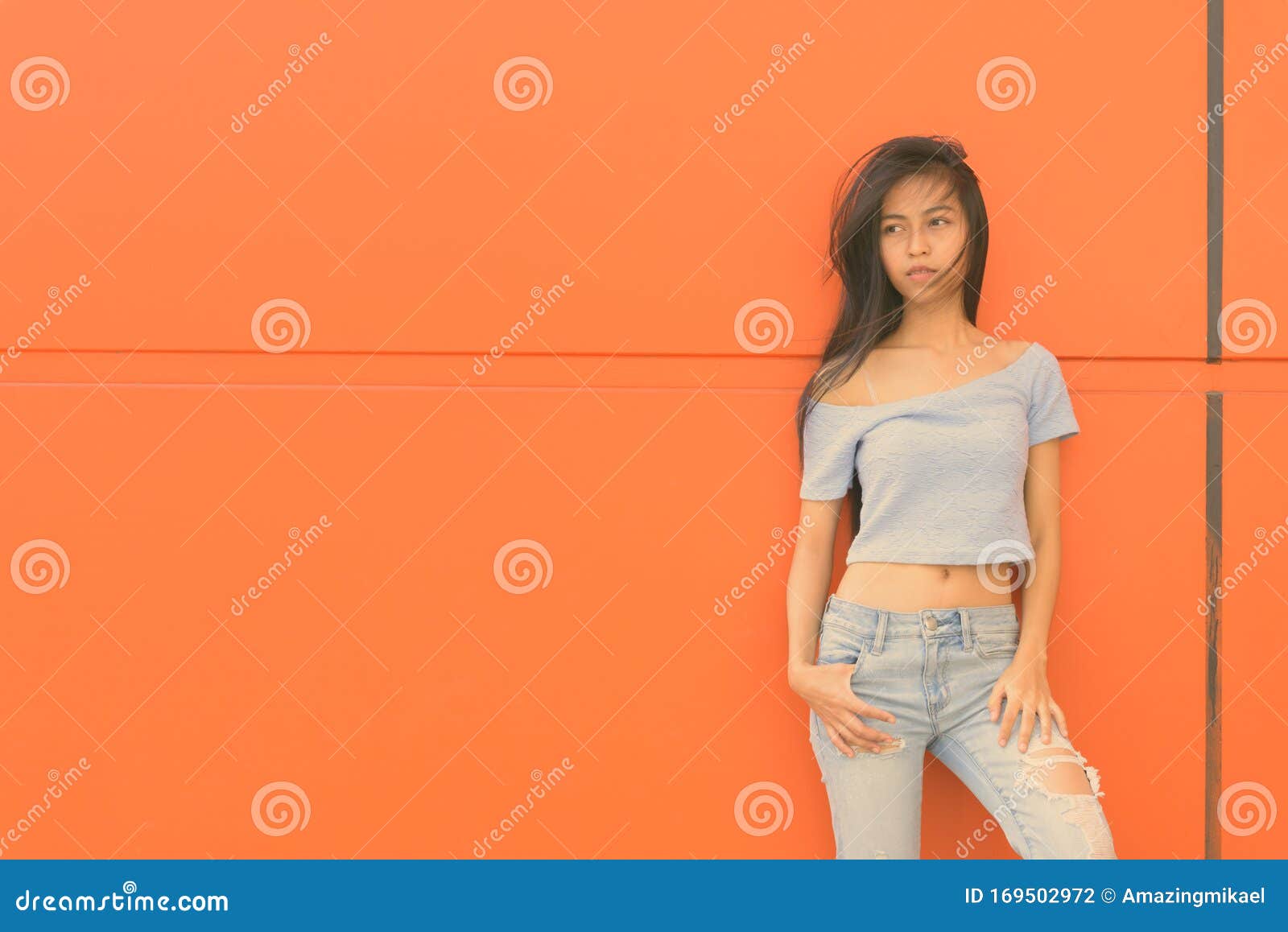 Young Beautiful Asian Teenage Girl Sitting While Using 