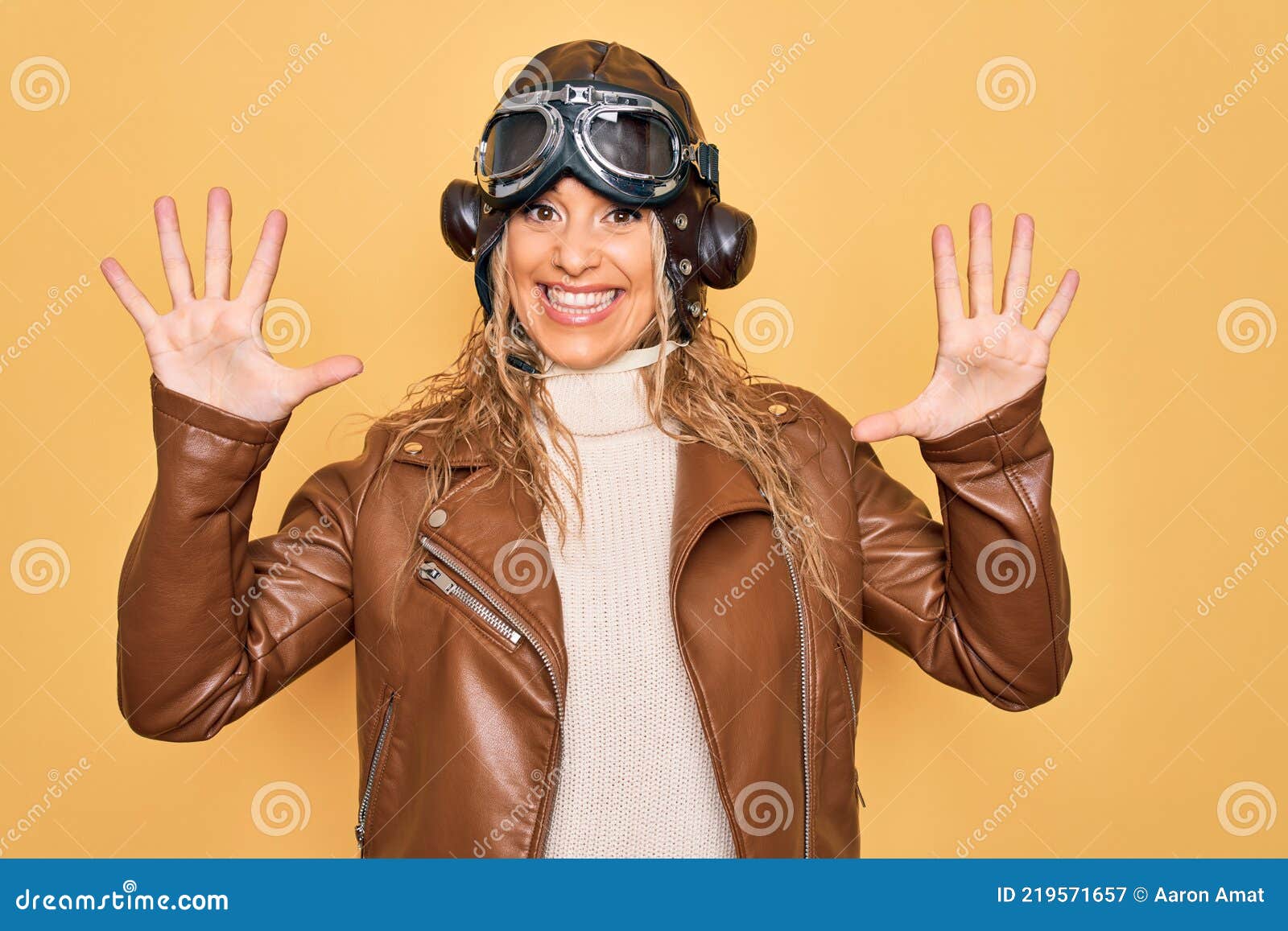 Young Beautiful Blonde Aviator Woman Wearing Vintage Pilot Helmet Whit Glasses And Jacket 