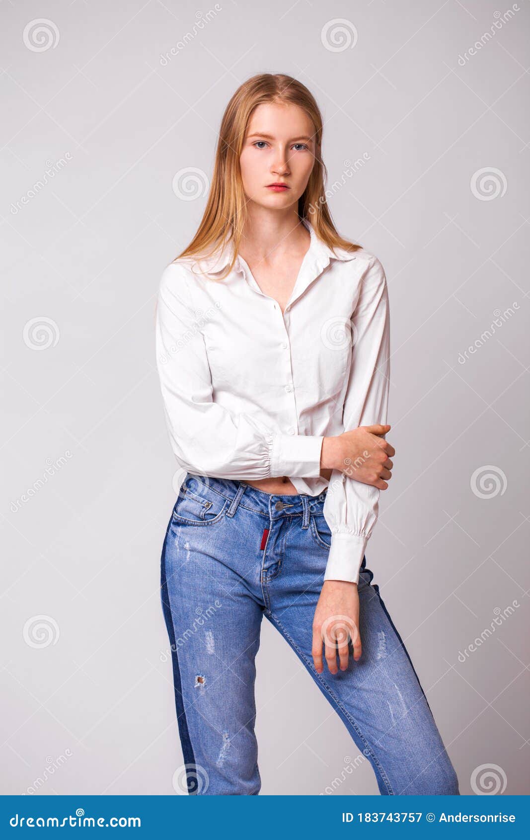 Young Beautiful Blonde Girl in a White Shirt. Studio Gray Isolated ...