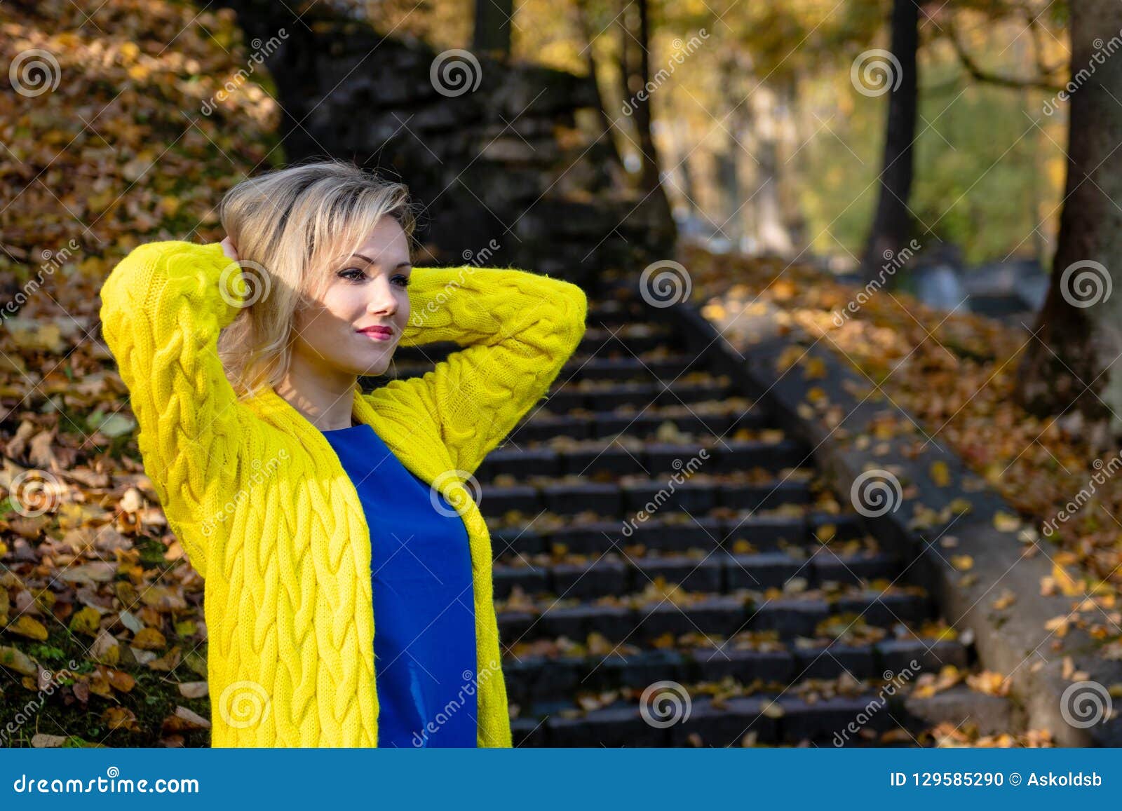 A Young, Beautiful, Blonde Woman Walking through the Autumn Park and ...