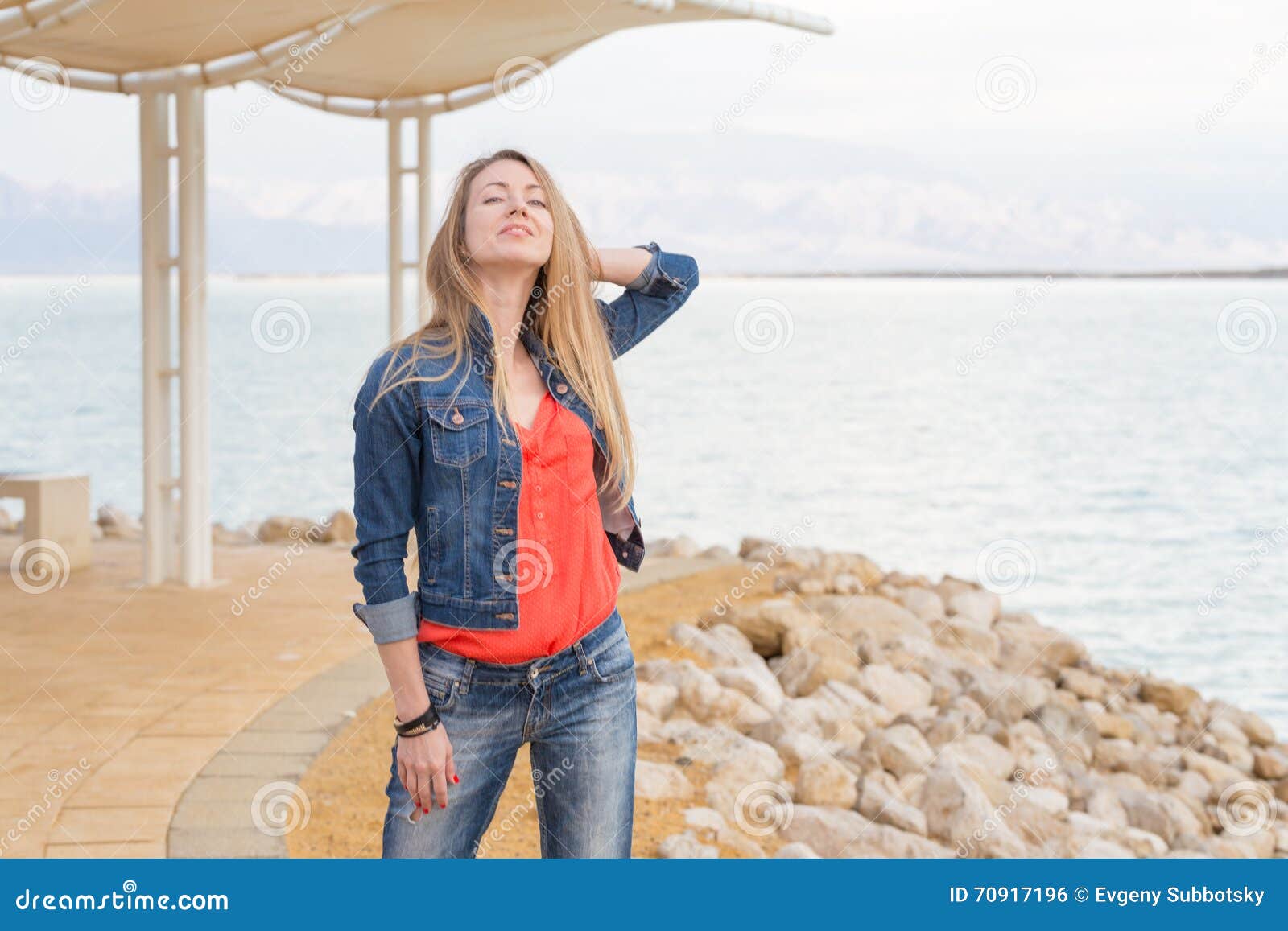 beautiful woman in jeans pants and leather coat and cap posing at lake beach  Stock Photo - Alamy