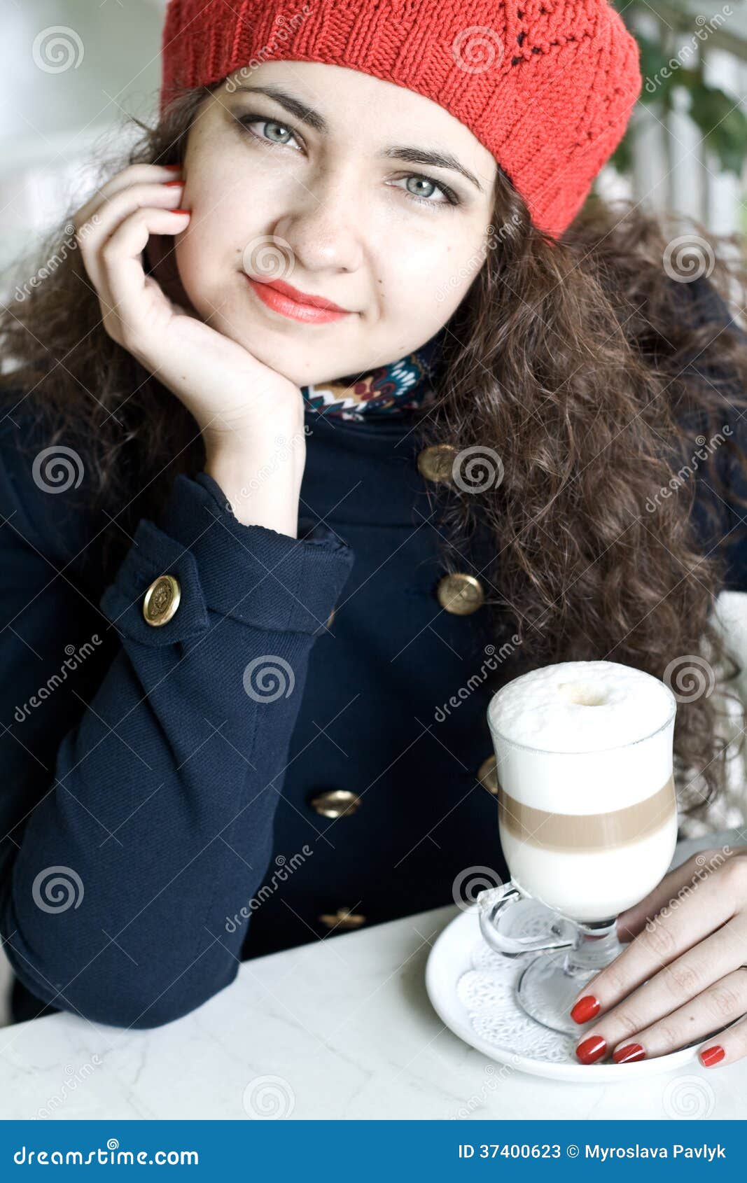 Young Beautiful Brunette with a Delicious Latte in a Cafe Stoc photo