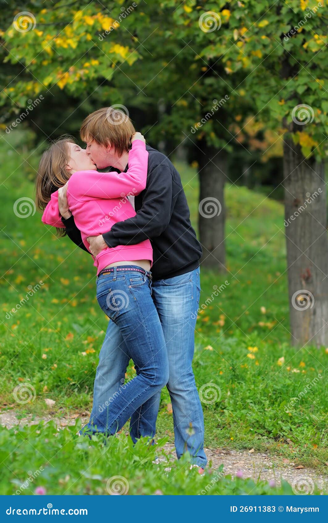 Ethnic boyfriend kissing cheerful girlfriend sitting together in grass ·  Free Stock Photo