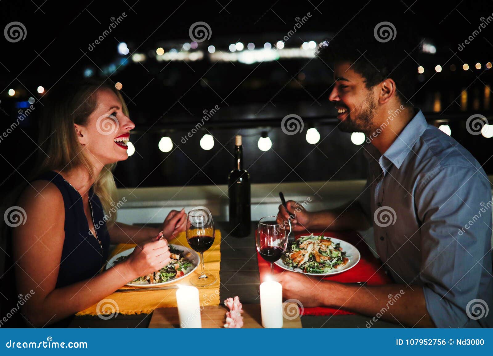 young beautiful couple having romantic dinner on rooftop