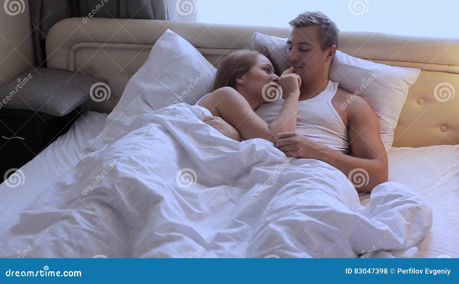 Young Beautiful Cute Couple Lying In Bed In The Morning Embracing