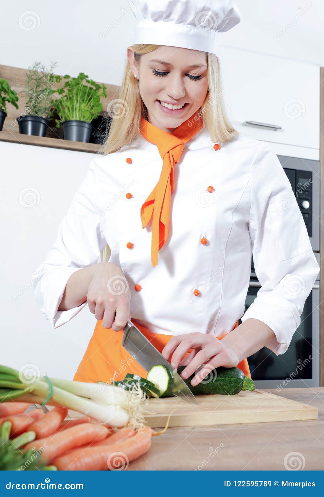 Young Beautiful Female Cook is Cooking in a Kitchen Some Food with