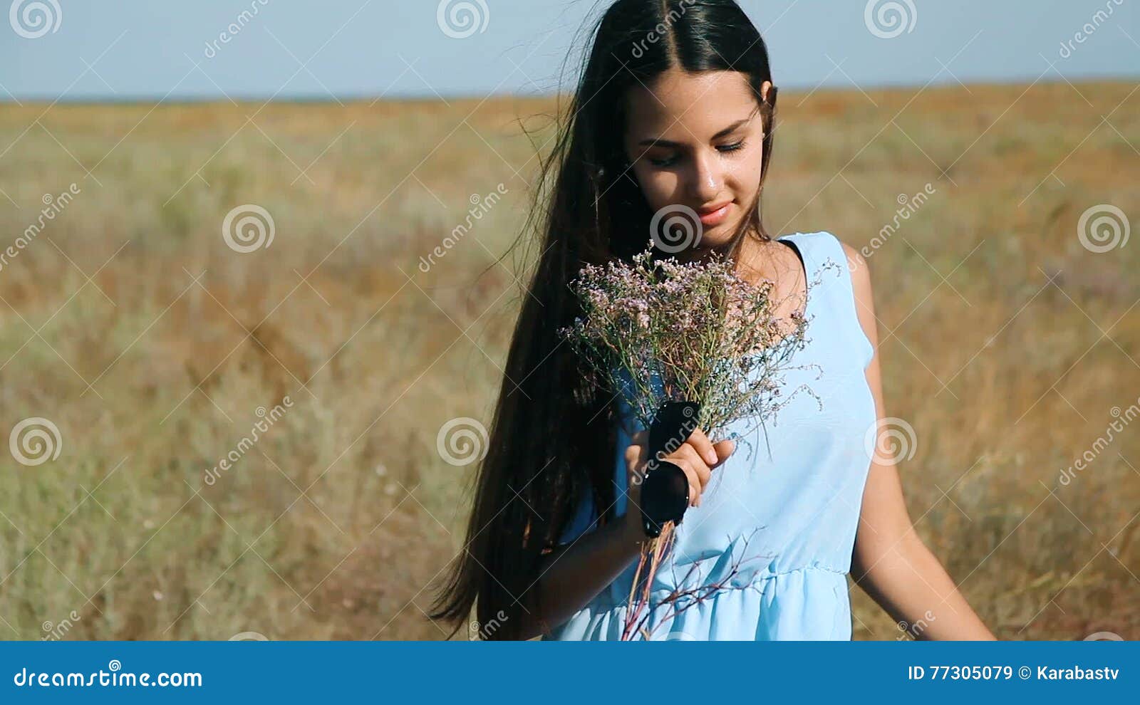 Young Beautiful Girl In A Blue Dress Enjoys Flowers Steppe A Young Woman In A Meadow Steppe Blossoming Sunny Meadow Stock Video Video Of Enjoy Outside