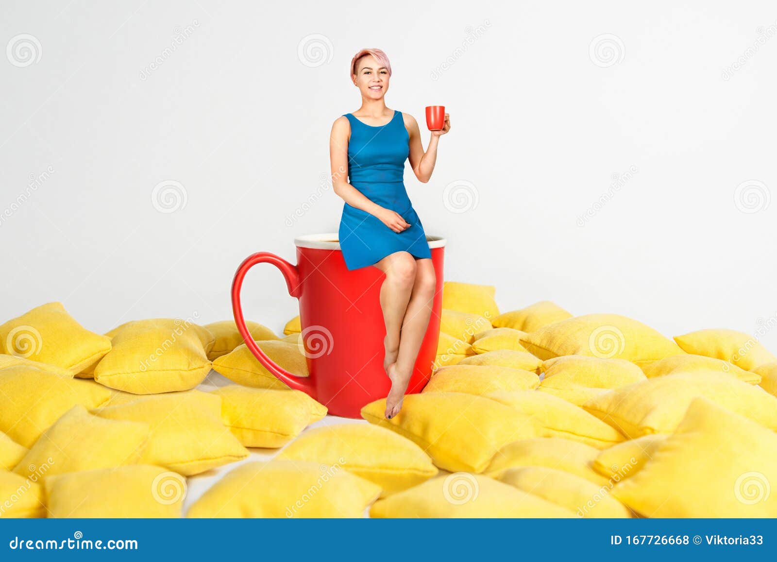 Young Beautiful Girl in Blue Dress Sits on a Huge Cup in a Yellow ...