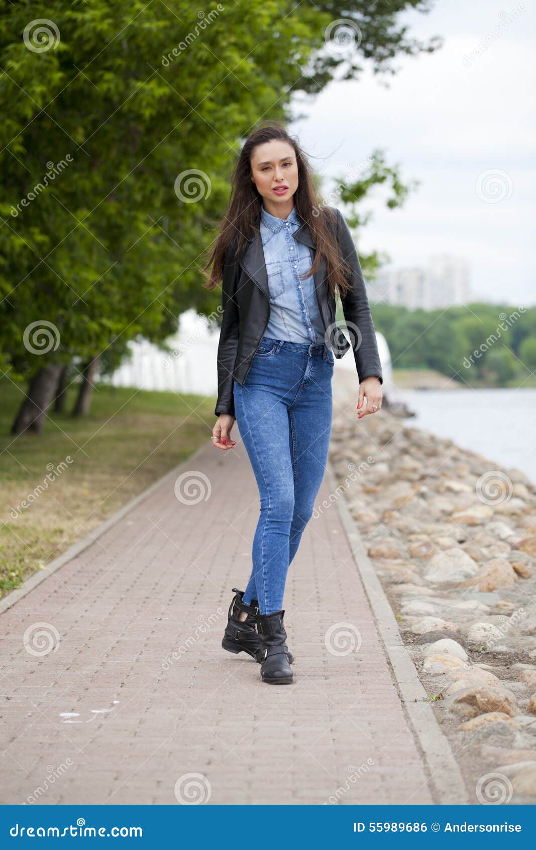 Young Beautiful Girl in Blue Jeans and a Blue Shirt on the Background ...