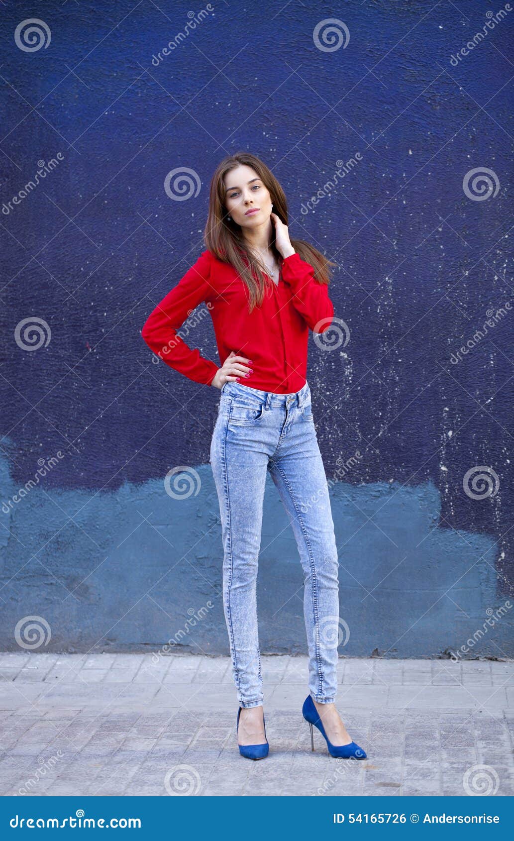 Young Beautiful Girl in Blue Jeans and a Red Shirt on the Background of ...