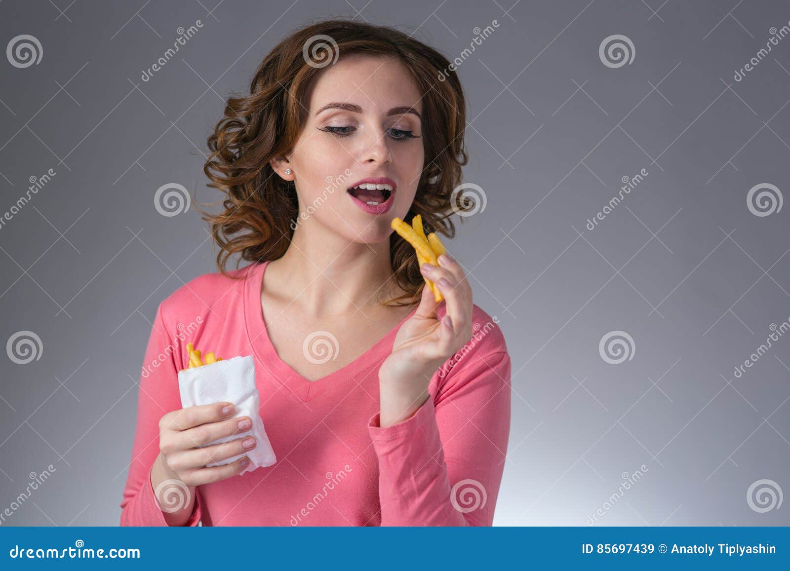 Young Beautiful Girl with a French Fries from a Fast Food Smiling Stock