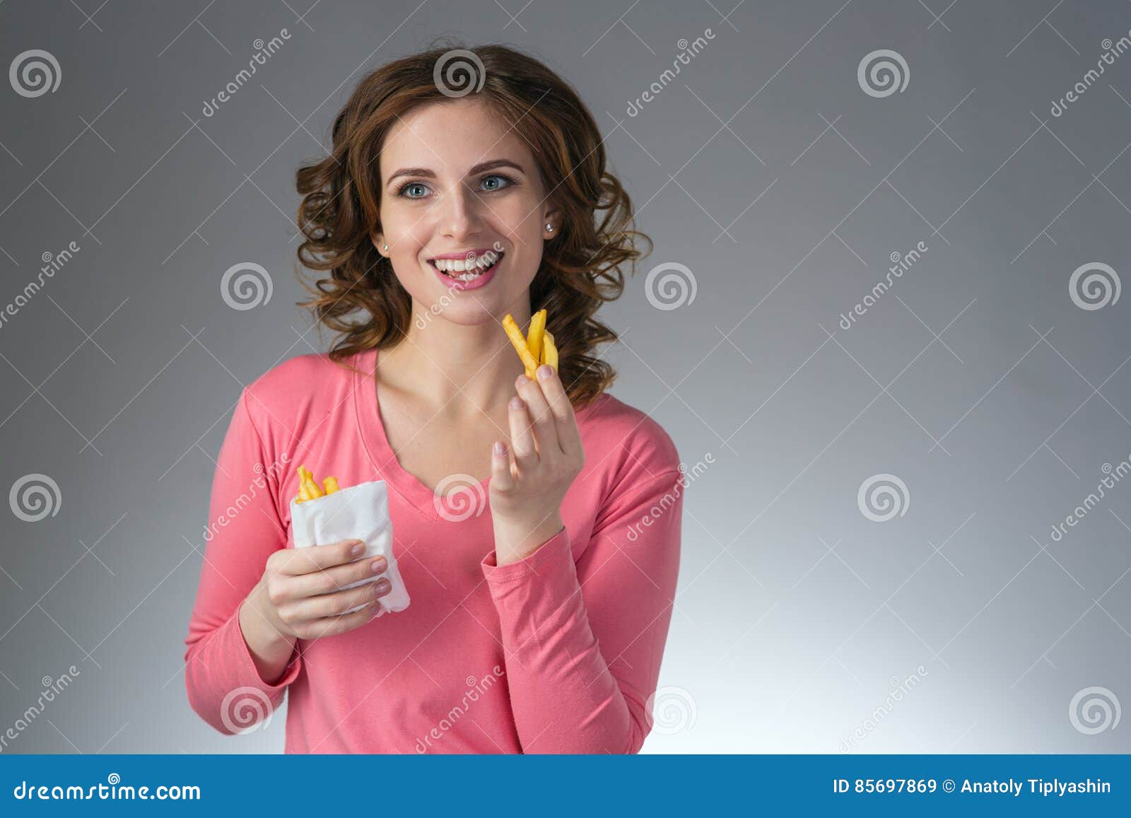 Young Beautiful Girl with a French Fries from a Fast Food Smiling Stock