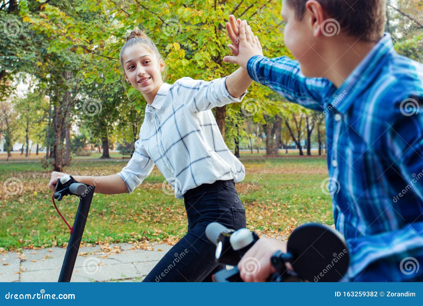 Beautiful Girl Giving High Five To Her Friend while they Both Ride ...