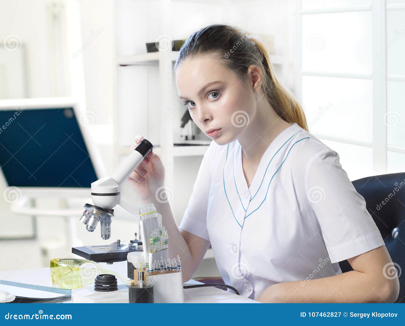 Young Beautiful Girl Lab Assistant Looks in a Microscope in a La Stock ...