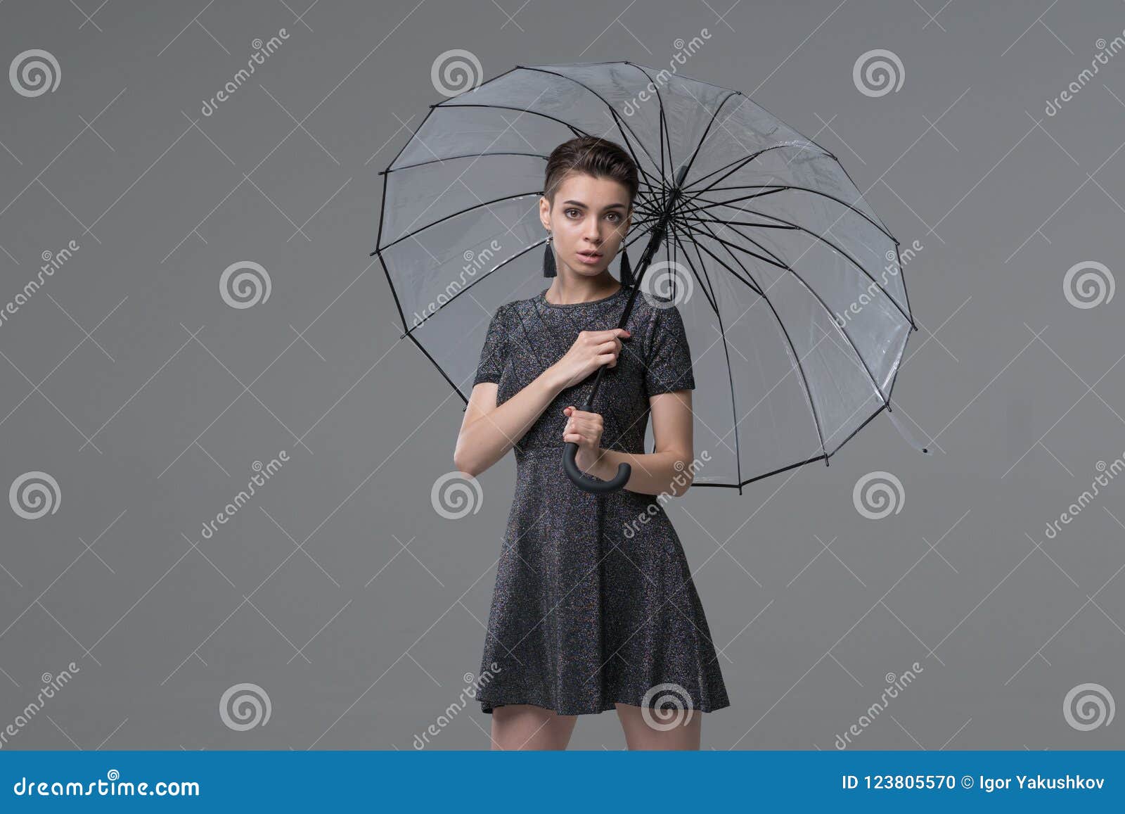 Photo Of A Cute Woman Wearing Scarf Holding Umbrella Posing Isolated Over  Yellow Wall Background. Stock Photo, Picture and Royalty Free Image. Image  112902307.