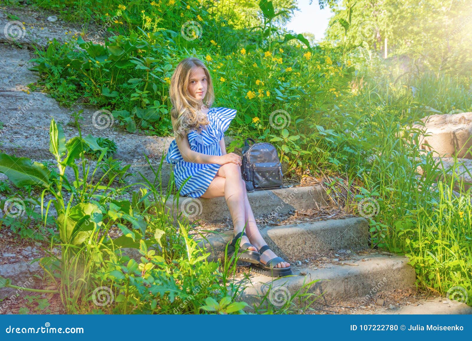 Young Beautiful Girl Sitting on the Stairs in the Park with Flower ...