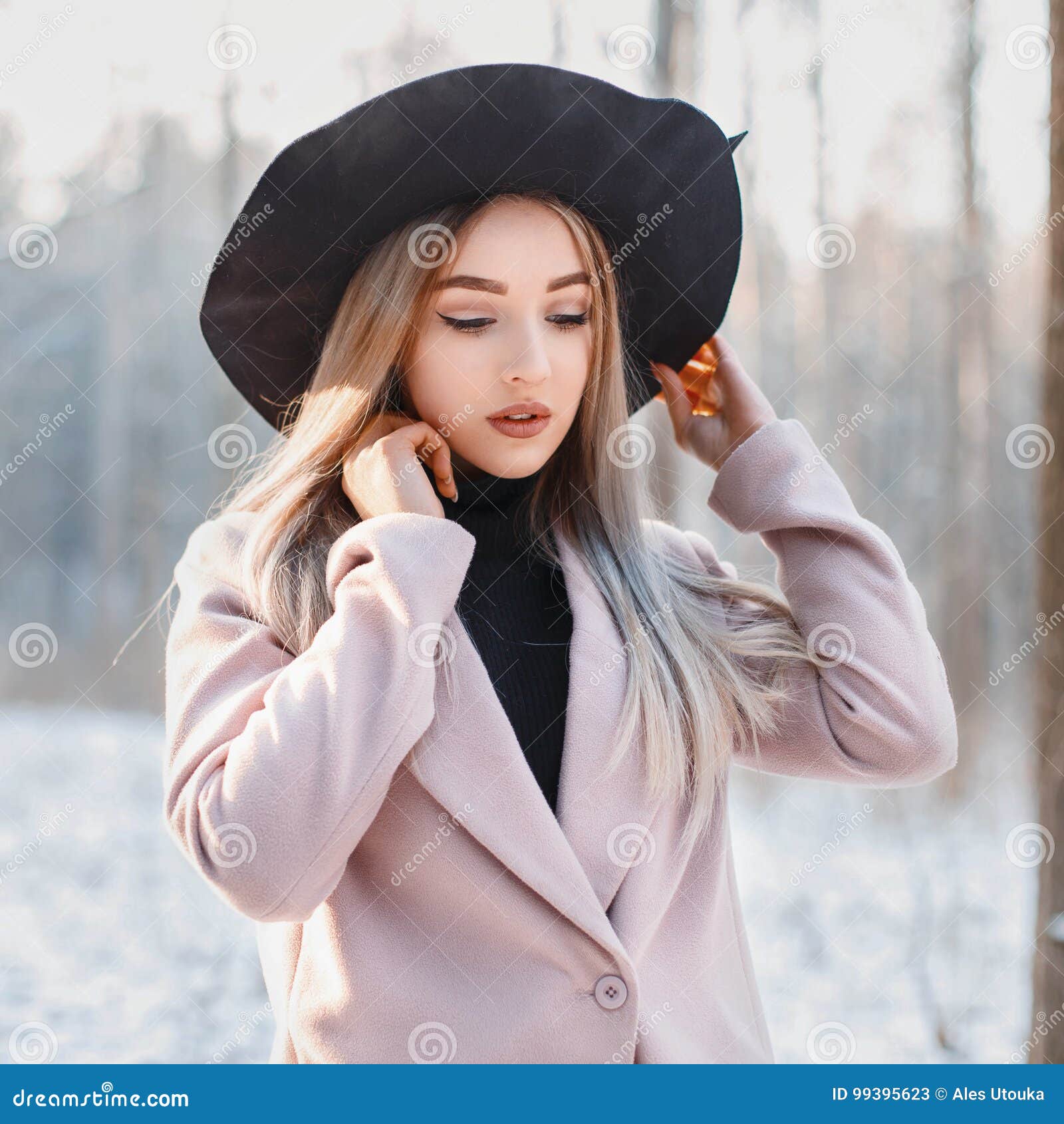 Young Beautiful Girl in Stylish Black Hat and Coat on a Background of ...