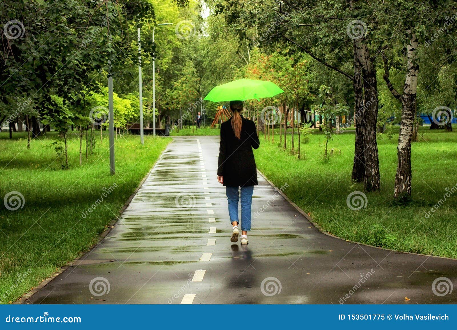 Young Beautiful Girl Walking Alone Under Green Umbrella In The City Park In Summertime Stock