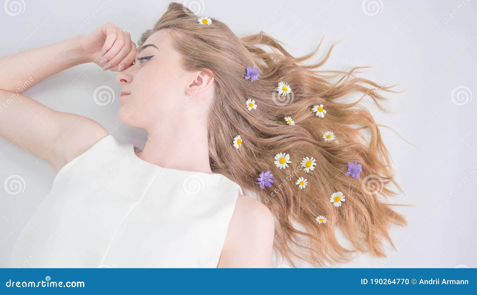 young beautiful girl on a white background,flowers in her hair,camomile in her hair,close-up,top view.