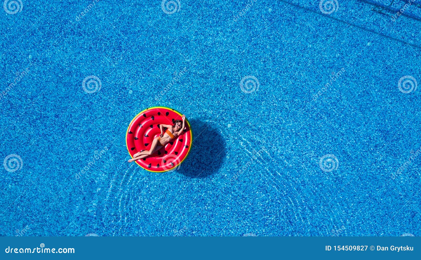 Young Beautiful Girl in a White Bikini Air Mattress Swims in the Pool ...