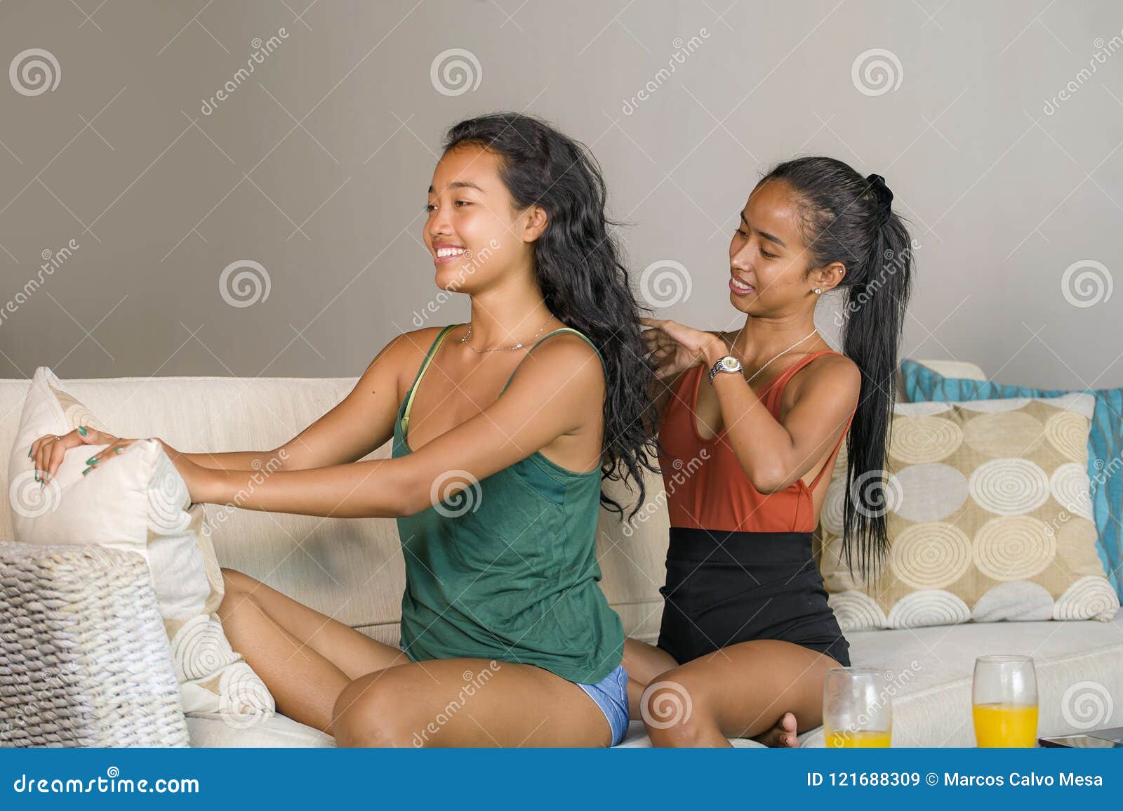 https://thumbs.dreamstime.com/z/young-beautiful-happy-asian-girlfriends-home-couch-one-girl-brushing-hair-other-woman-helping-preparing-dat-121688309.jpg