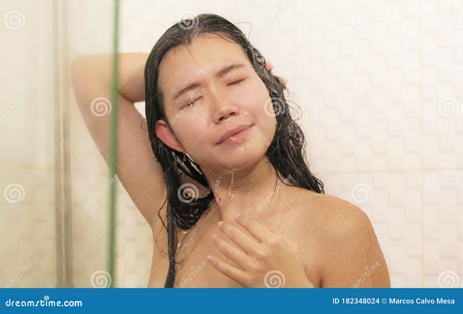 Pretty, young woman taking a long hot shower washing her 