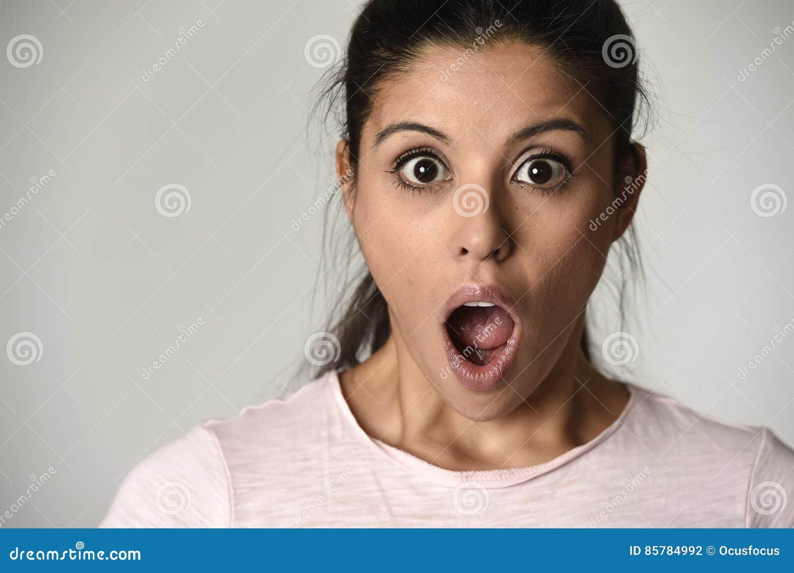 young beautiful hispanic surprised woman amazed in shock and surprise with mouth big opened