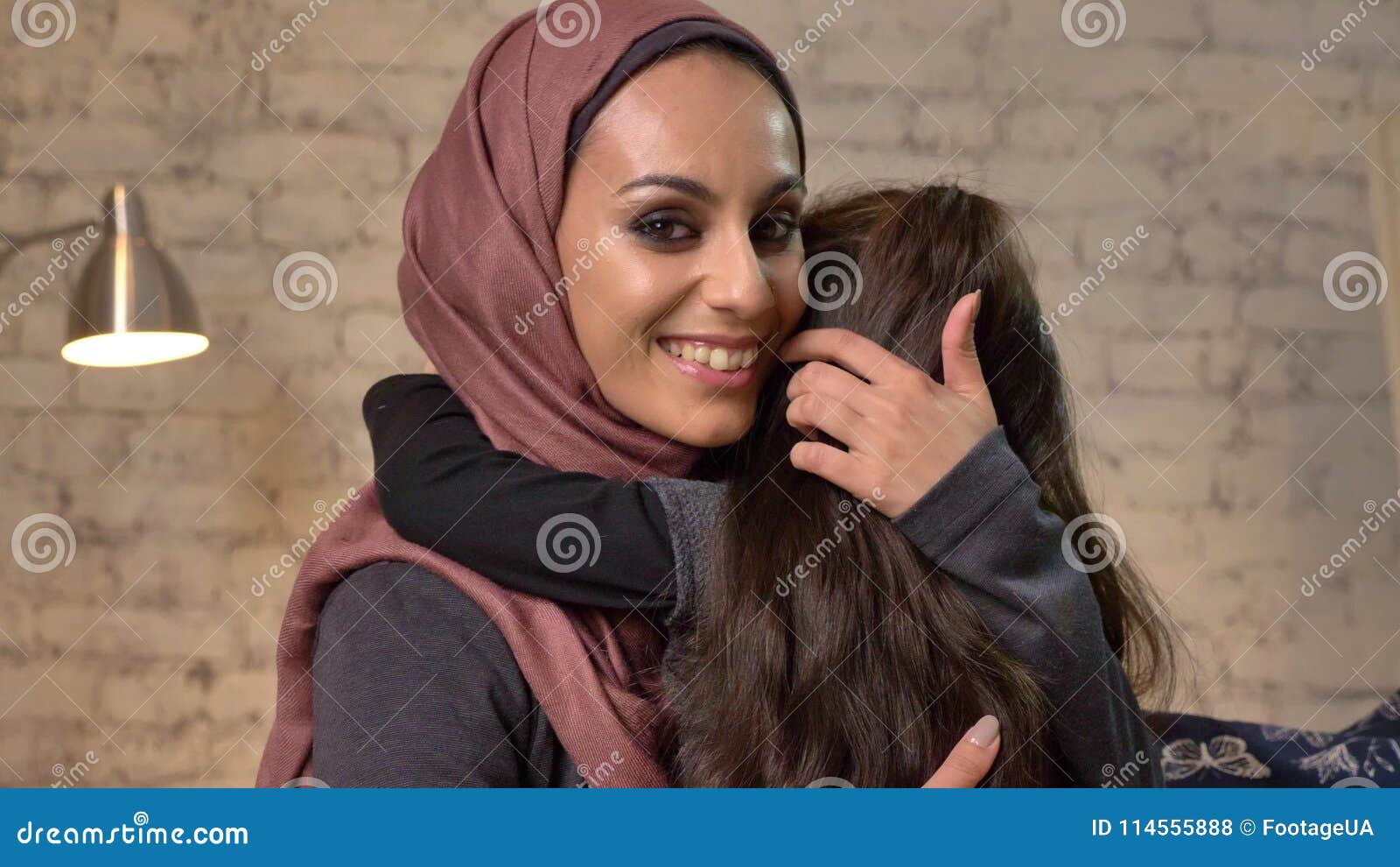 Young Beautiful Mother In Hijab Hugs Her Little Daughter Looks At 