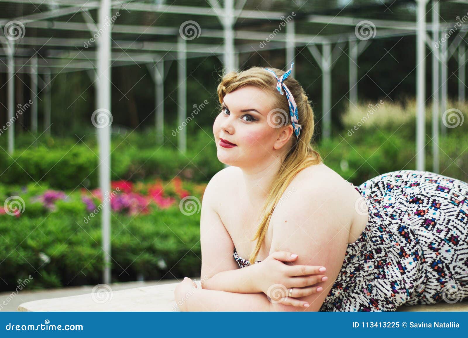 Young Beautiful Plus Size Modelt in Black Bra Holding Mannequin