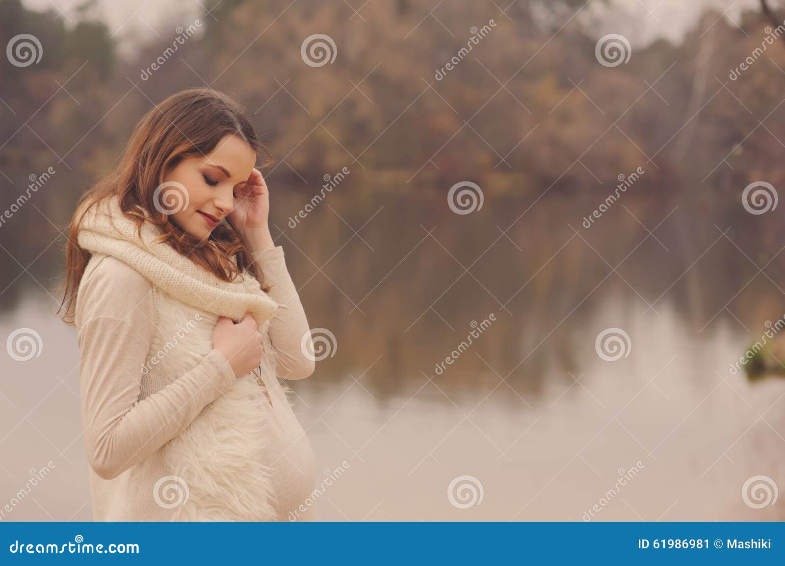 young beautiful pregnant woman on cozy warm walk on autumn riverside, warm toned, soft focus