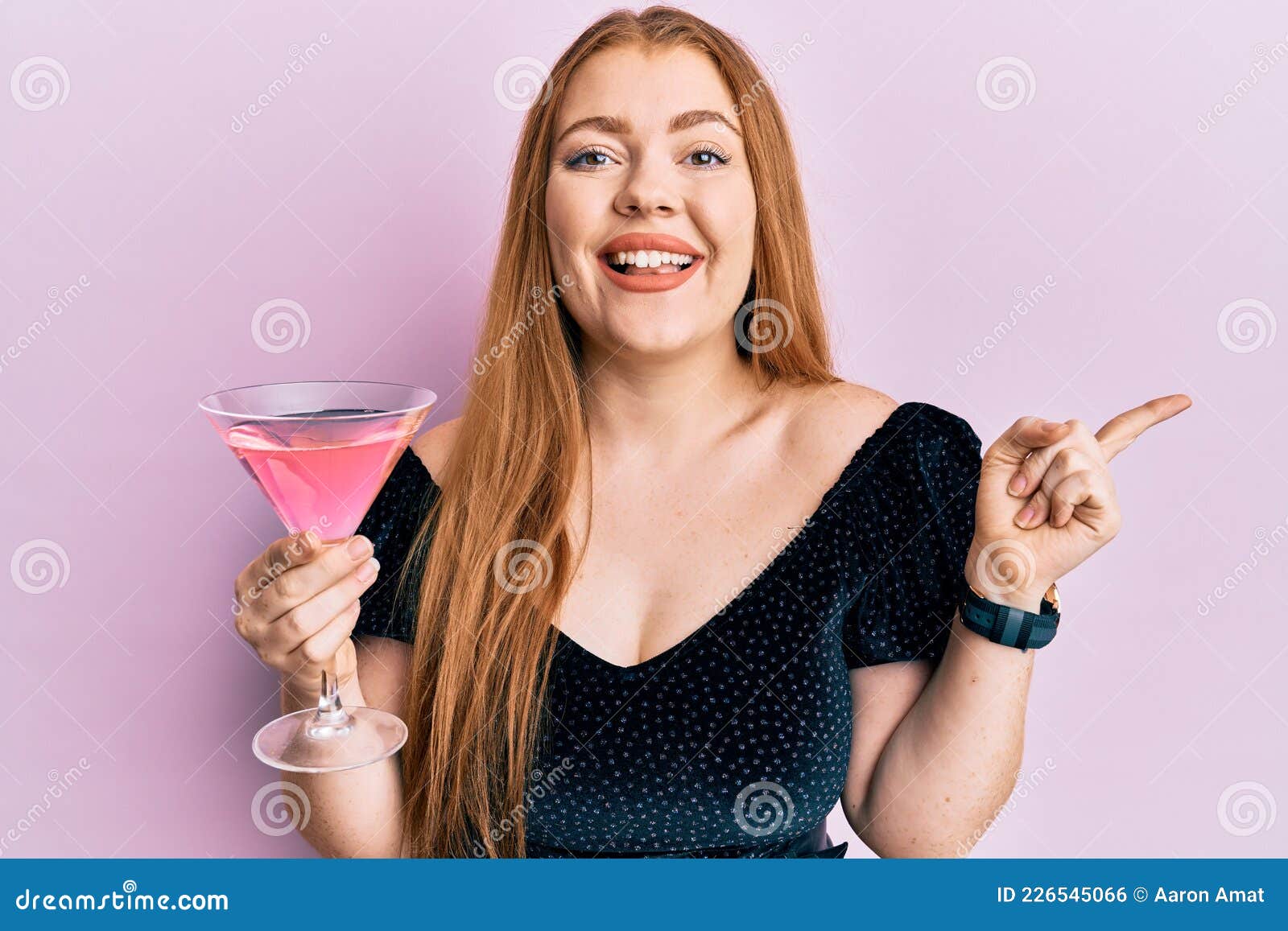 Young Beautiful Redhead Woman Drinking Tropical Cocktail With Alcohol Smiling Happy Pointing