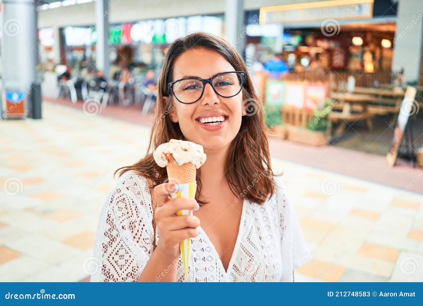 Young Beautiful Woman Eating Ice Cream Cone At The Shopping Center On A Sunny Day Of Summer On 