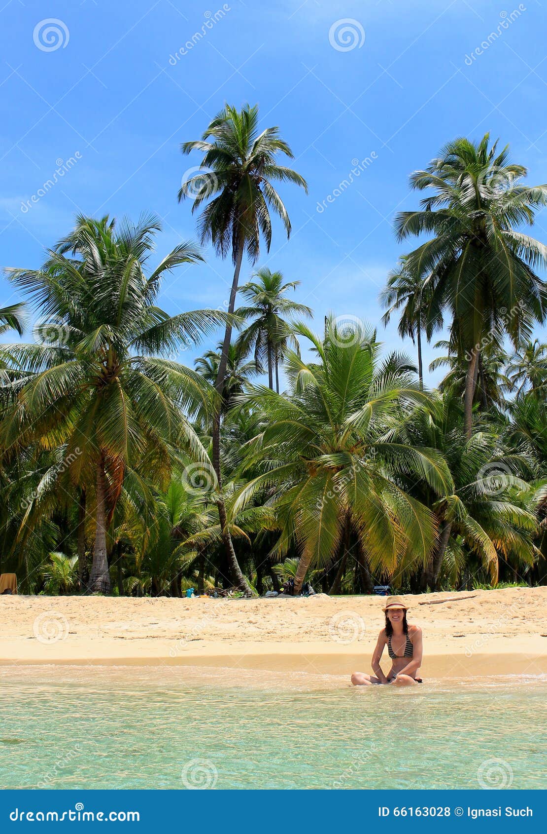 young beautiful woman enjoying her time and resting close to the sea in the southern beach of pelicano island, panama.